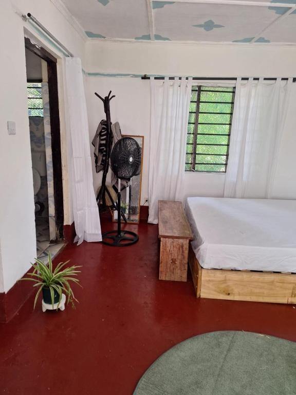 基利菲Seaside Tranquil Beach studio的一间卧室配有一张床、一张桌子和风扇