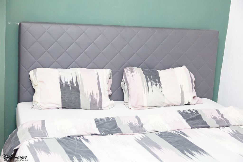 two beds with white and grey sheets and pillows at Ubuntu House - Charleroi in Charleroi