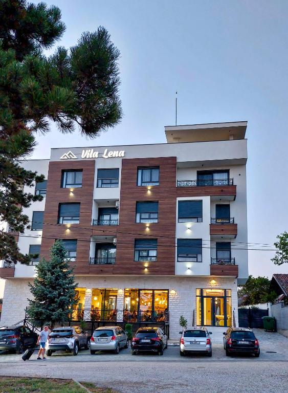 a building with cars parked in front of it at POOL RESORT- Vila Lena- Apartman 2 in Vrdnik