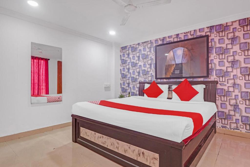 Un dormitorio con una cama grande con almohadas rojas. en Hotel O New Lakeview Palace, en Hyderabad