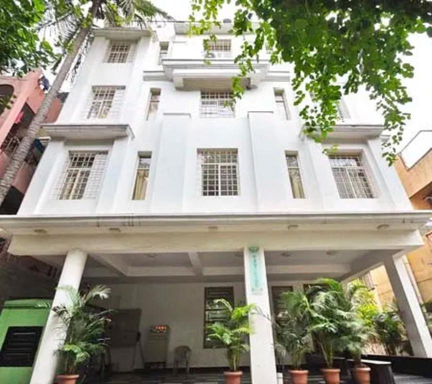 un edificio bianco con piante in vaso di fronte di Tea Pavilion a Bangalore