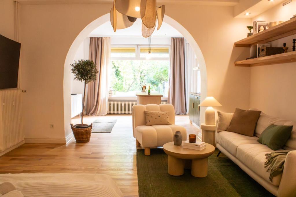 NiederdorlaにあるMit Terrasse und Blick ins Grüneのソファとテーブルのあるアーチ型のリビングルーム