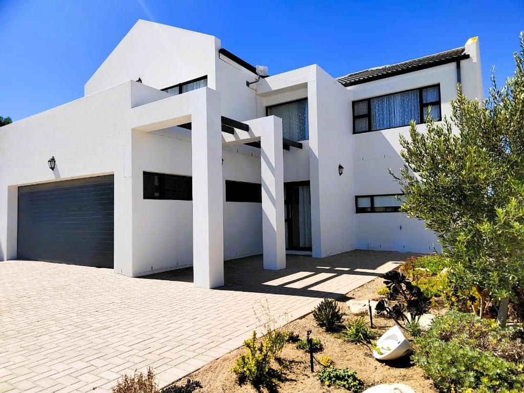 a white house with a garage at Greenview Haven in Stompneusbaai