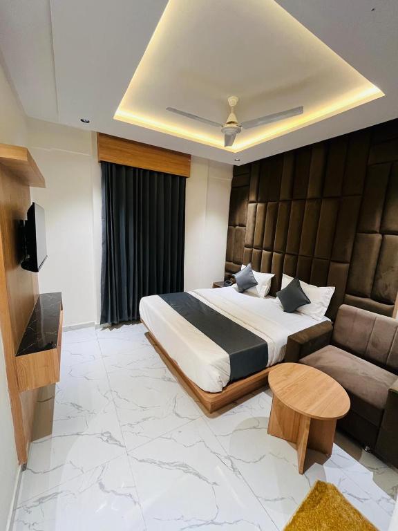 ein Schlafzimmer mit einem großen Bett und einer Couch in der Unterkunft Hotel Pacific Inn in Ahmedabad