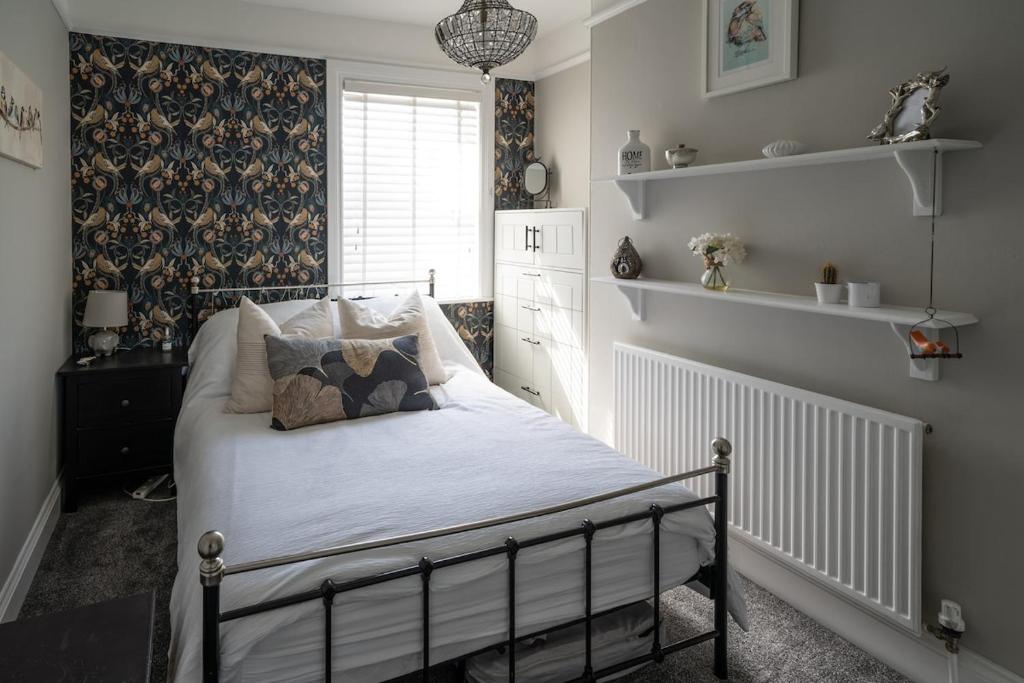 a bedroom with a bed with pillows on it at Seaside 5-Bed Coastal Getaway in Exmouth