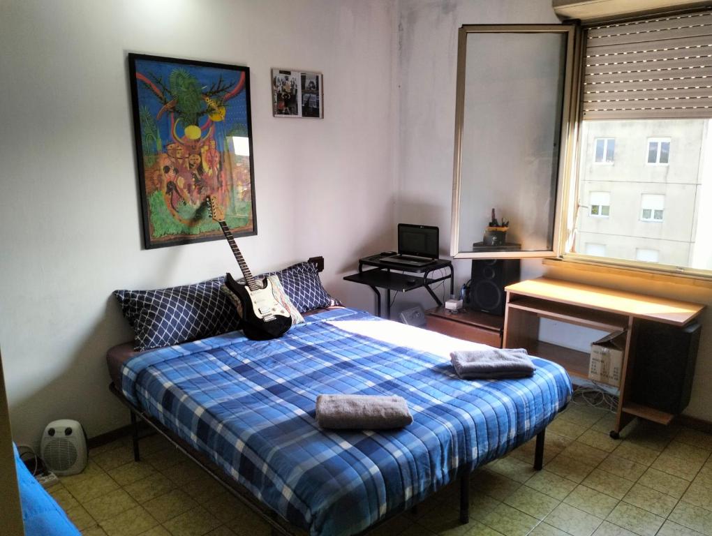 Un dormitorio con una cama con una guitarra. en Camere Artisti Musicisti Viaggiatori Vacanze, en Verona