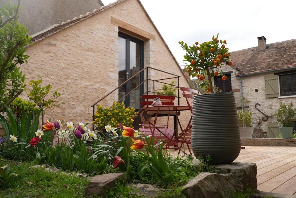 un jardín con flores frente a una casa en Studio de charme, en Achères-la-Forêt