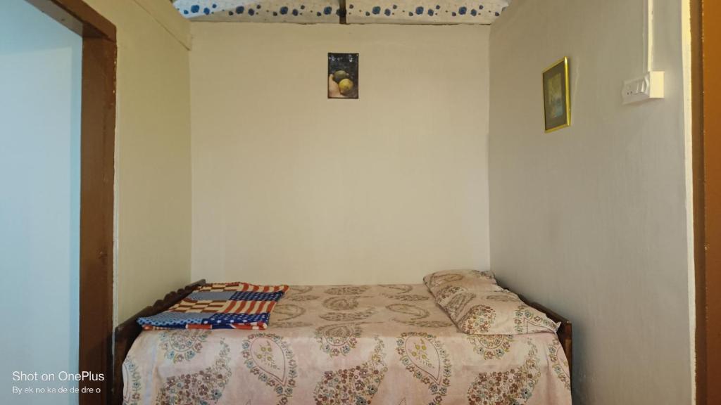 a small bedroom with a bed in a room at Verdant Vagamon Farm House in Vagamon