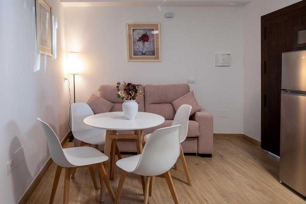 ein Wohnzimmer mit Tisch, Stühlen und Sofa in der Unterkunft Vivienda rural La Puentezuela in Grazalema