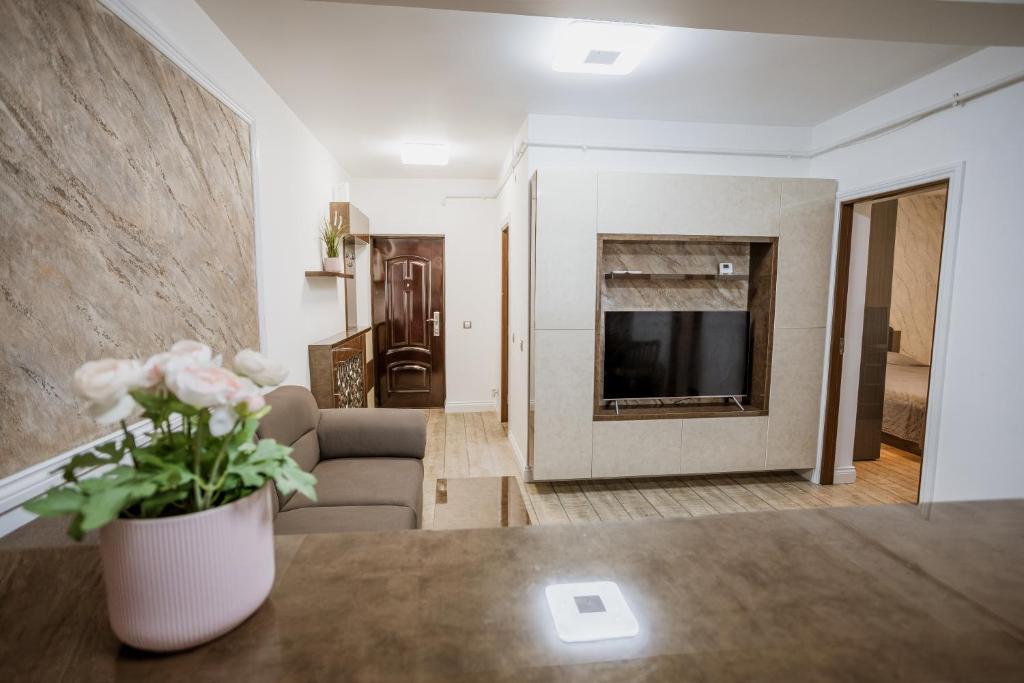 a living room with a vase of flowers on a table at APARTAMENT de LUX SIBIU in Sibiu