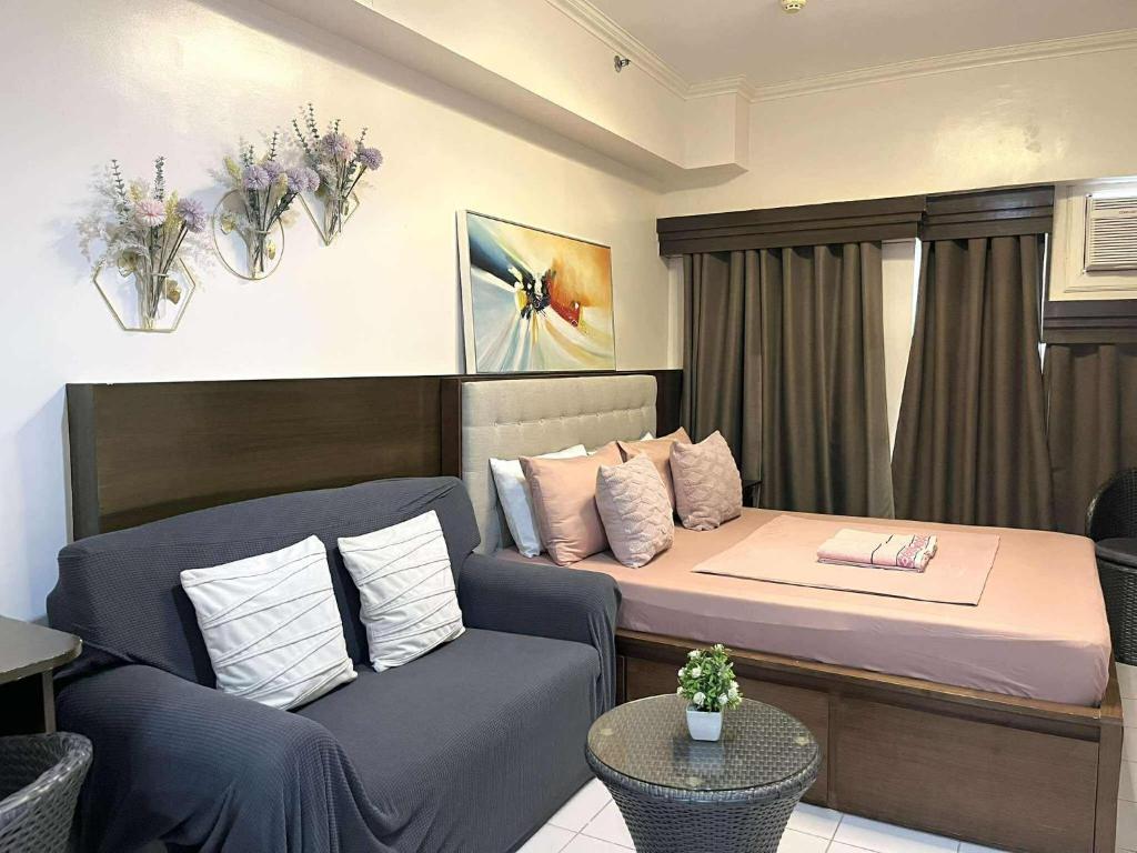 ein kleines Zimmer mit einem Bett und einer Couch in der Unterkunft City Land Tagaytay Prime in Ulot
