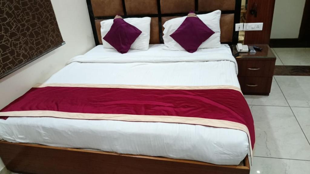 a bed with purple and white pillows in a room at Hotel Roselle inn in Jāmb