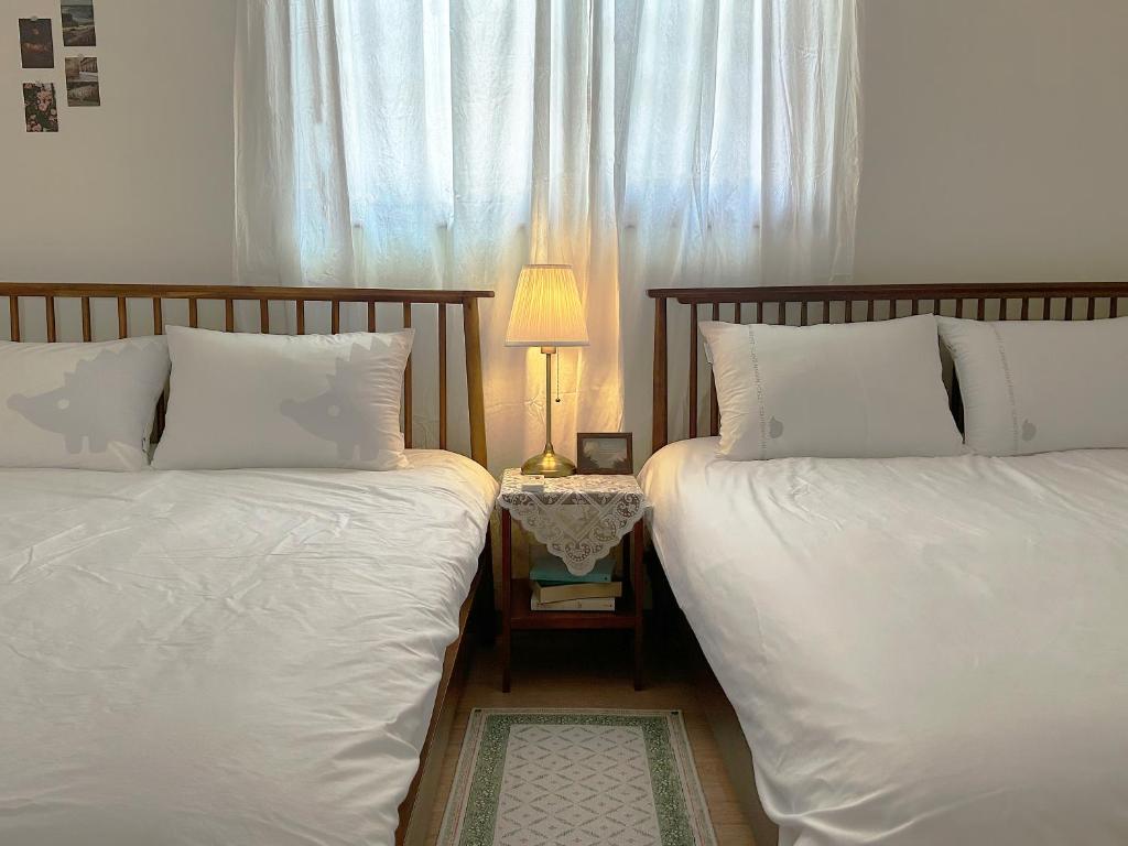 Dos camas una al lado de la otra en un dormitorio. en 들락스테이 Deullak Stay, en Millak-tong