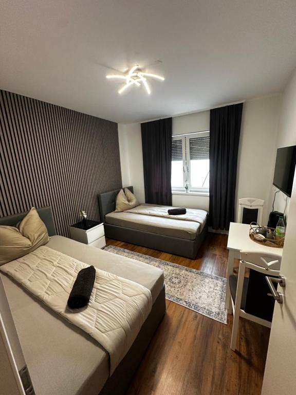 a hotel room with two beds and a desk at Zimmervermietung Wels 2 in Wels