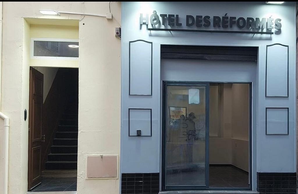 a building with a door and a sign on it at Hôtel des Réformés in Marseille