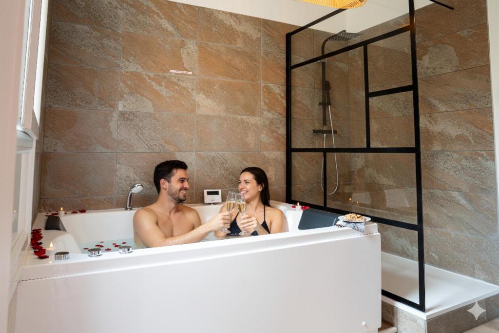a man and a woman sitting in a bath tub at L'Ecrin d'Albi - Love Room - 1 chambre in Albi