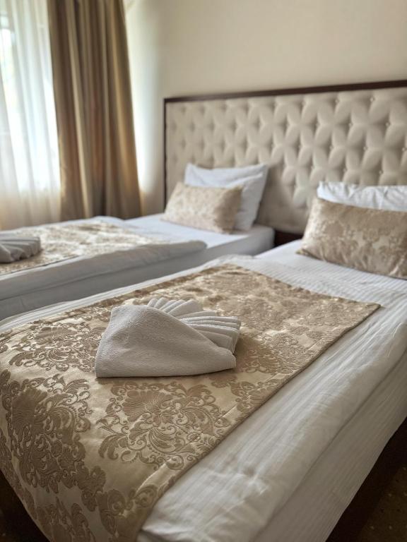 two beds in a hotel room with a pillow on it at Hotel Turist 98 in Jajce