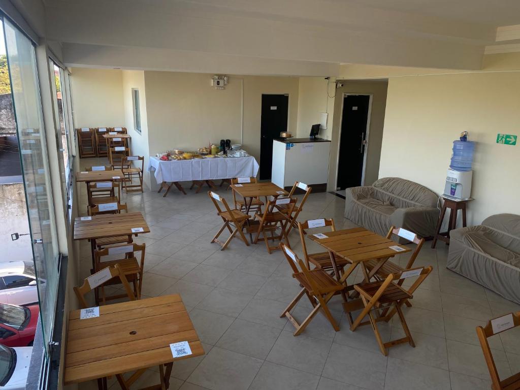 a room with wooden tables and chairs and a table at Hotel Renascer pojuca in Pojuca