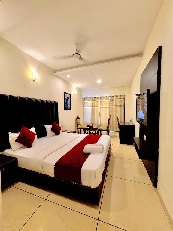 a bedroom with a large bed in a room at Hotel JB Grand Residency Zirakpur Chandigarh # lift #Balcony Rooms # Banquet Hall # Family Rooms in Chandīgarh