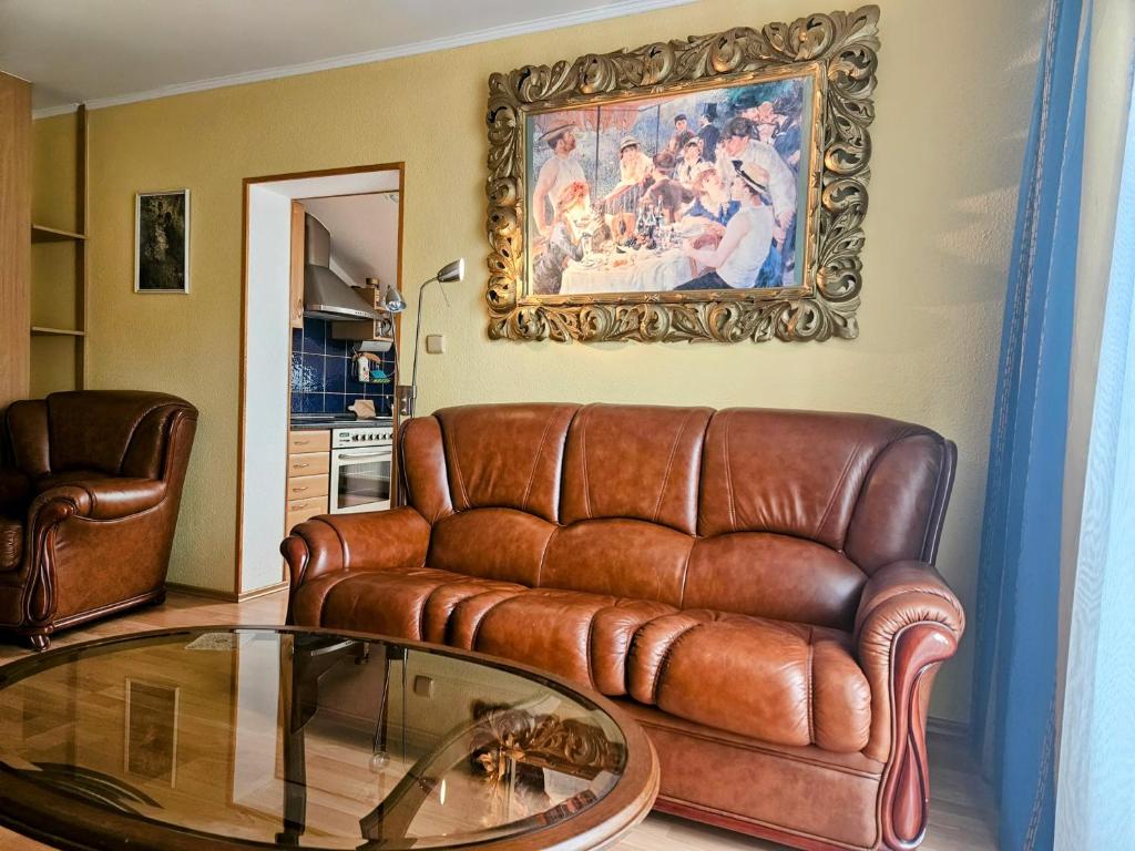 a living room with a leather couch and a glass table at Apartmán Sofie Mariánské Lázně in Mariánské Lázně