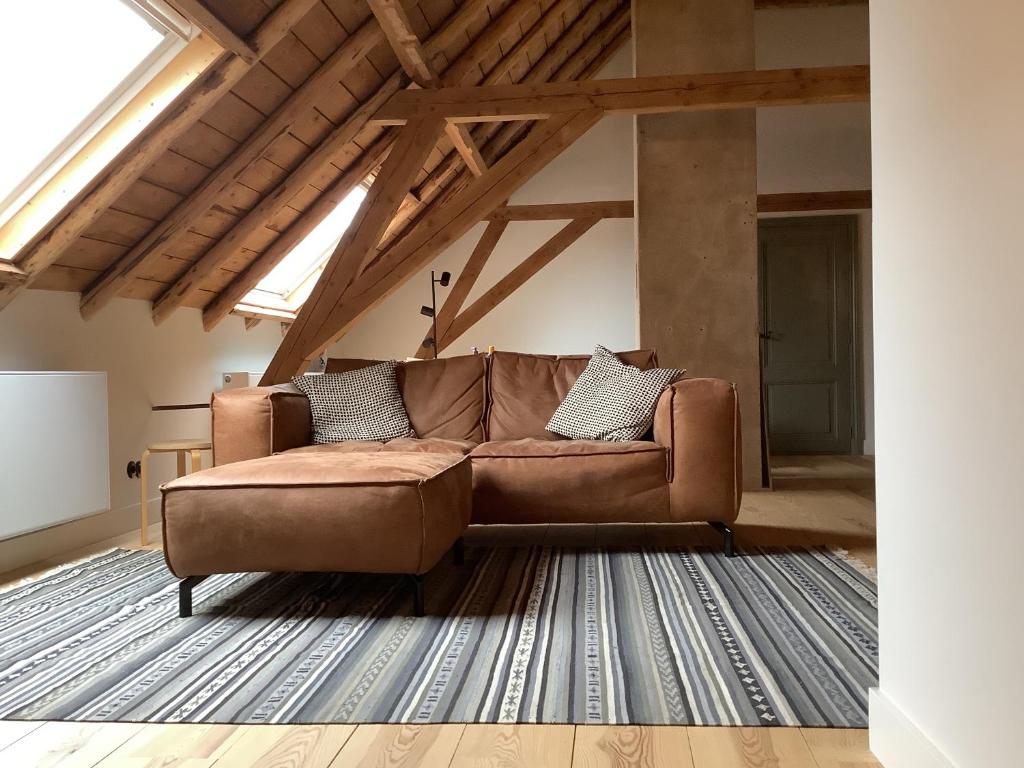 a living room with a brown couch in a loft at Slapen in Bronkhorst in Bronkhorst