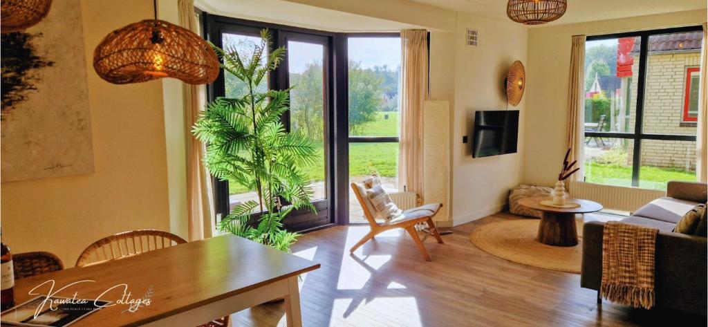 a living room with a table and chairs and a living room at Lakeview 'Rotorua' 4-6 pers by Kawatea Cottages in Ewijk