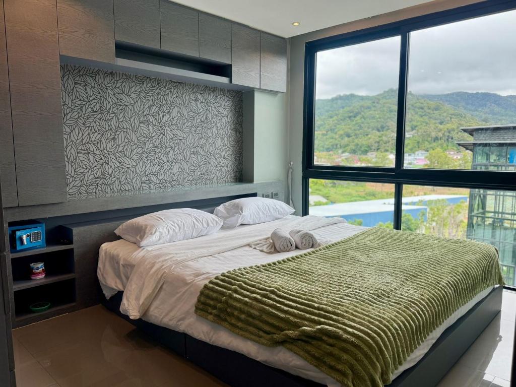 a bedroom with a large bed with a large window at Room in Kamala at Citygate Condo in Kamala Beach