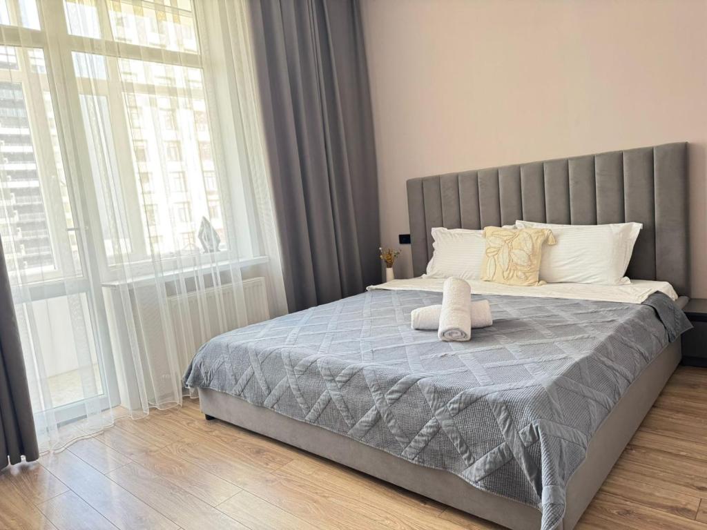 a bedroom with a large bed with a large window at Astana Design Nest in Taldykolʼ