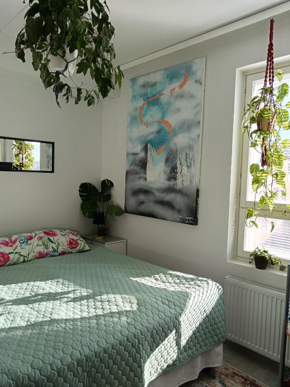 a bedroom with a bed and a painting on the wall at King's Oak Jungle in Helsinki