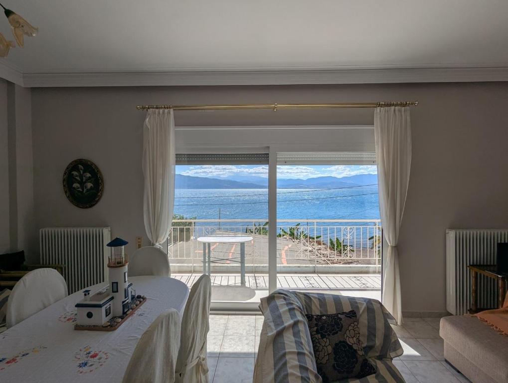 een woonkamer met uitzicht op de oceaan bij Comfortable waterfront cottage in Paralía Rachón