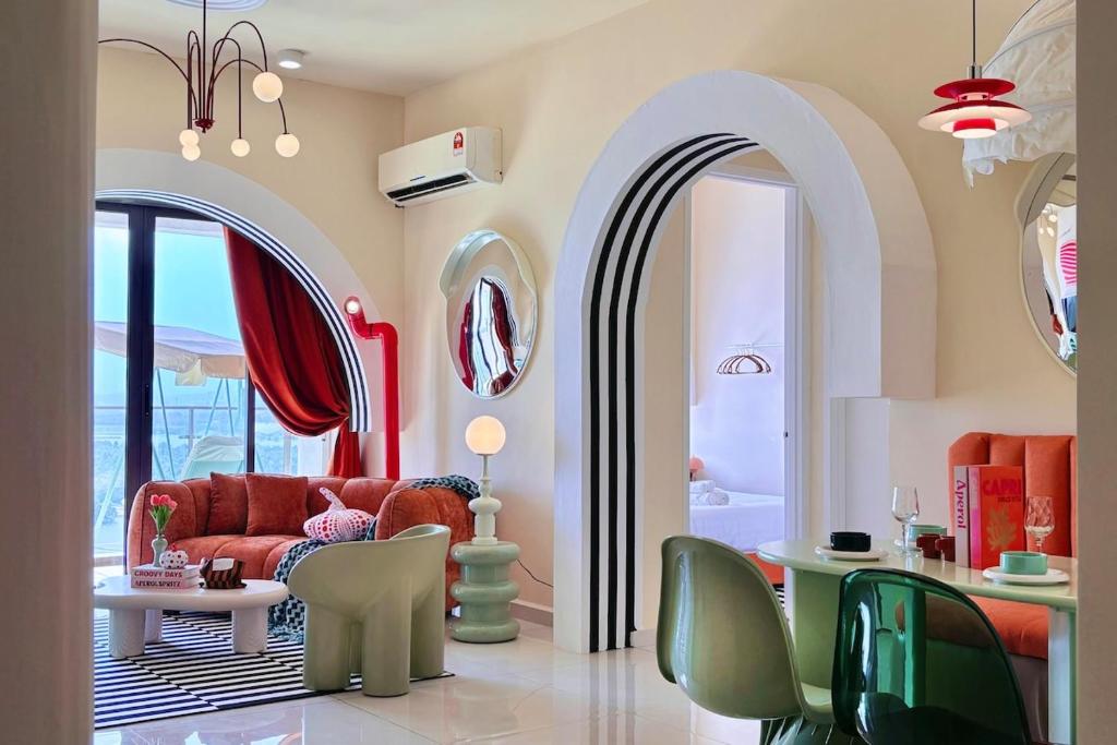 a living room with a red couch and some chairs at Dooga Ins-Retro Wonderland Seaview Bathtub by Doogahome Homestay in Johor Bahru