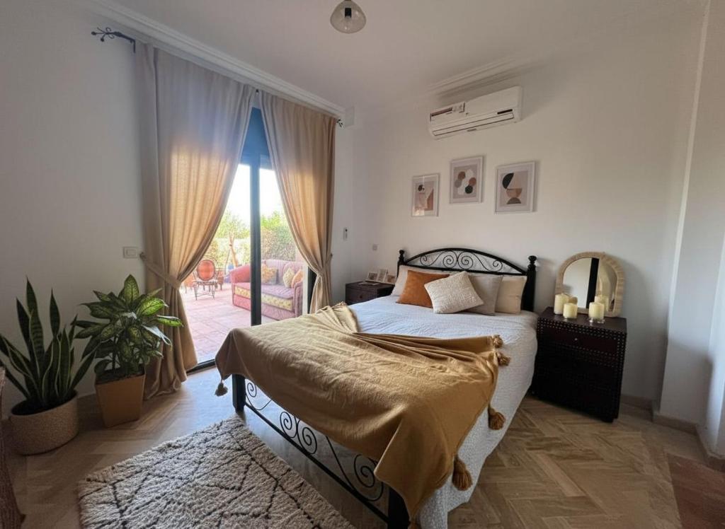 una camera da letto con un letto e una grande finestra di Atlas Golf resort a Marrakech