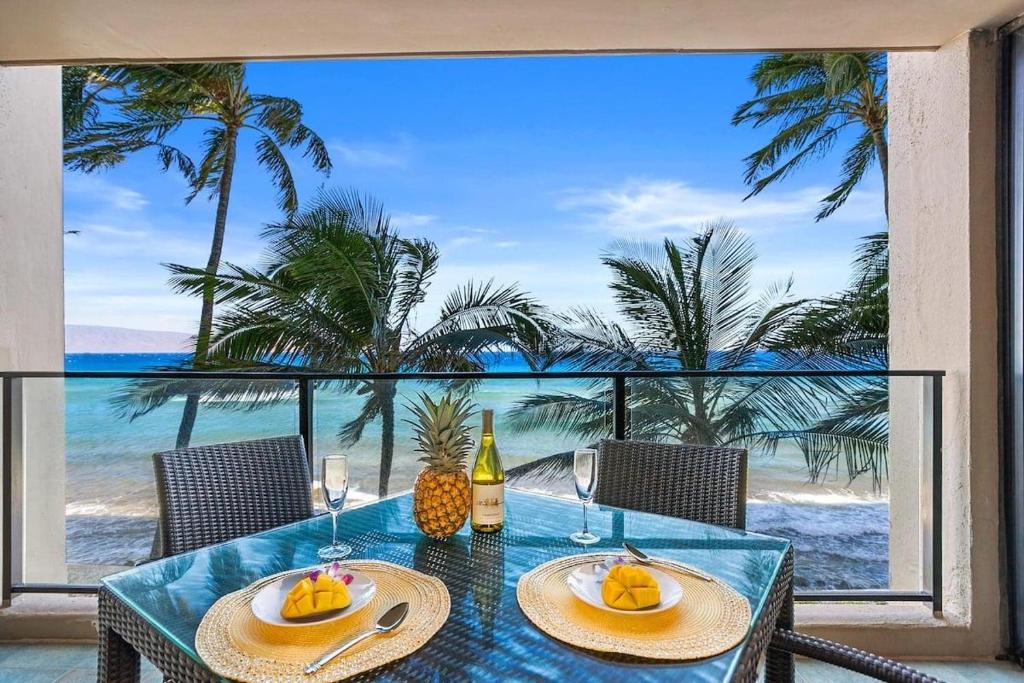a dining table with a view of the ocean at Mahana 307 · MA 307 OceanFront Condo w Pool AC in Kahana