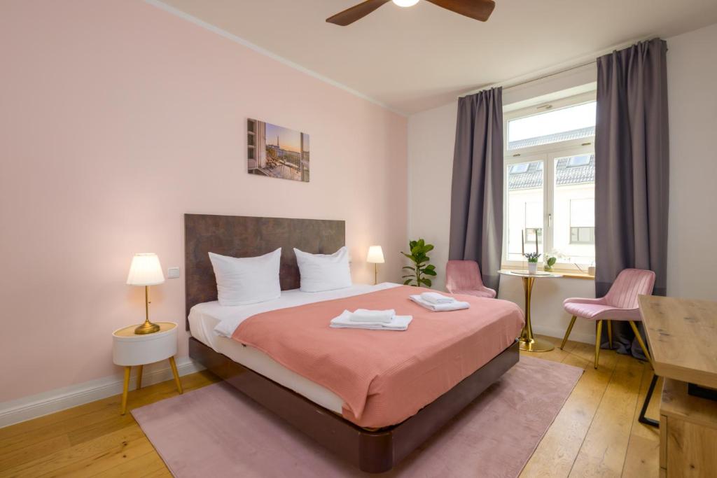 ライプツィヒにあるApartments an der Arena Leipzigのベッドと机と窓のある寝室