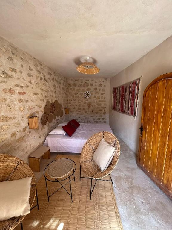 a bedroom with a bed and a table and chairs at Azul Chenini in Shenini
