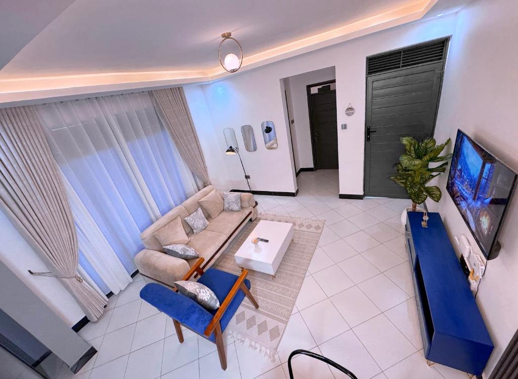 a living room with a couch and a tv at Mody Haven in Kampala