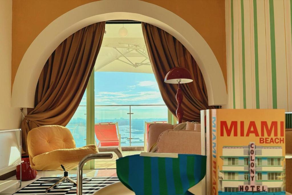 a living room with a chair and a book shelf at Dooga Ins-Retro Pastelland Seaview Bathtub by Doogahome Homestay in Johor Bahru