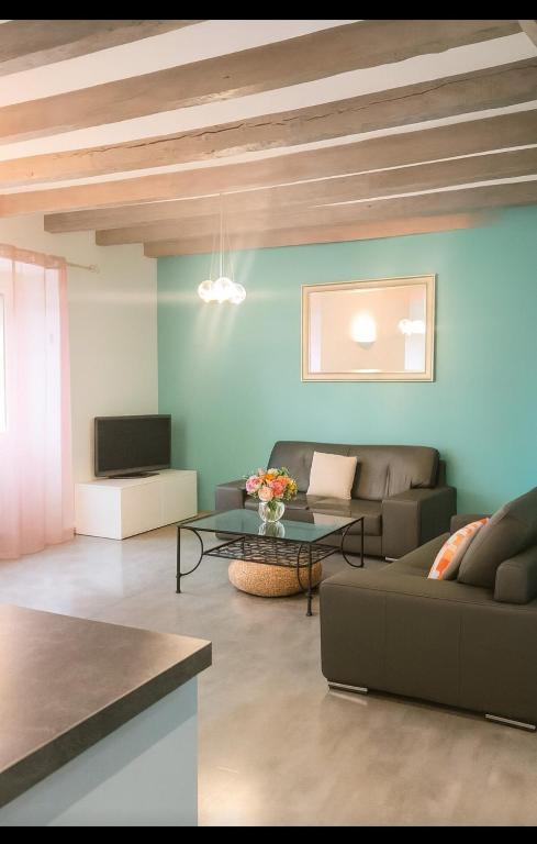 a living room with a couch and a table at Maison de village chaleureuse avec terrasse 3 étoiles in Serrières-en-Chautagne