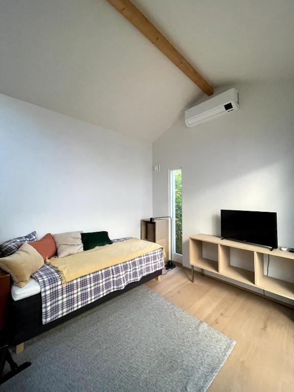 a bedroom with a bed and a flat screen tv at Guesthouse at Roland's in Uppsala