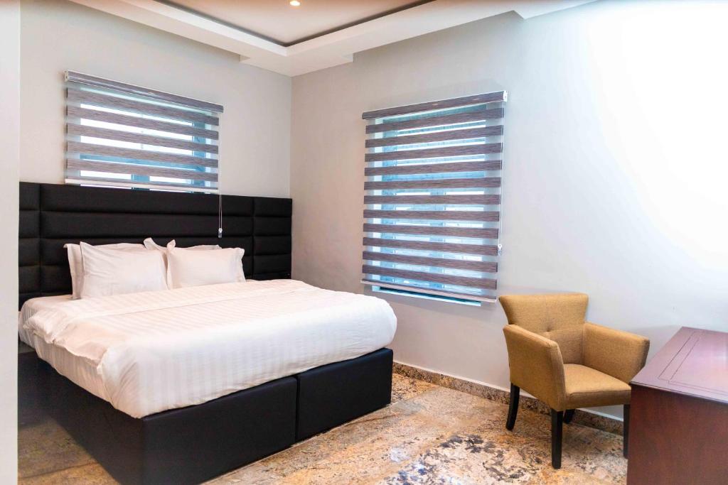 a bedroom with a bed and a desk and a chair at King Georges Court in Mama