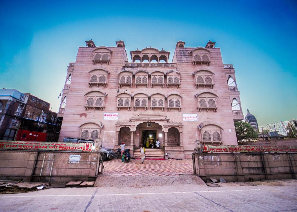 AyodhyaOmji Kathiya Mandir - 2km from Ram Temple的一座大型砖砌建筑,前面有人