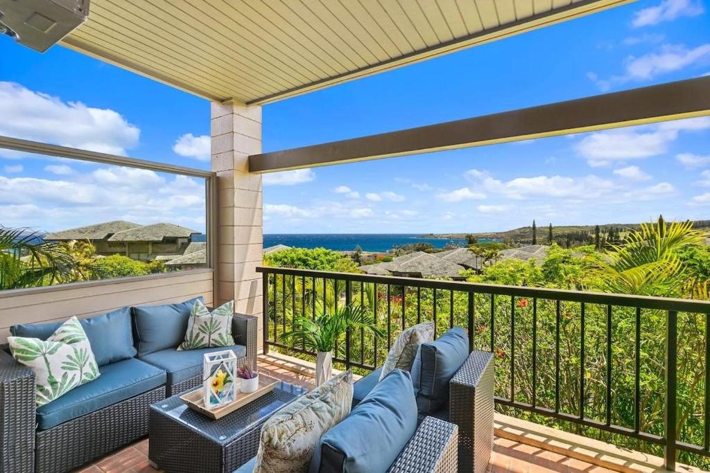 un patio con un sofá azul en el balcón en Kapalua Ridge Villas 1414 · KRV 1414 Remodeled 2BD Kapalua Vill, en Kahana