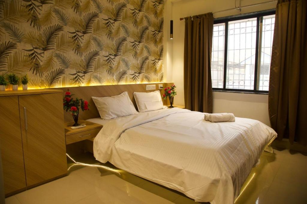 a bedroom with a large white bed with a window at S&K villa 3 BHK PRIVATE POOL in Lonavala