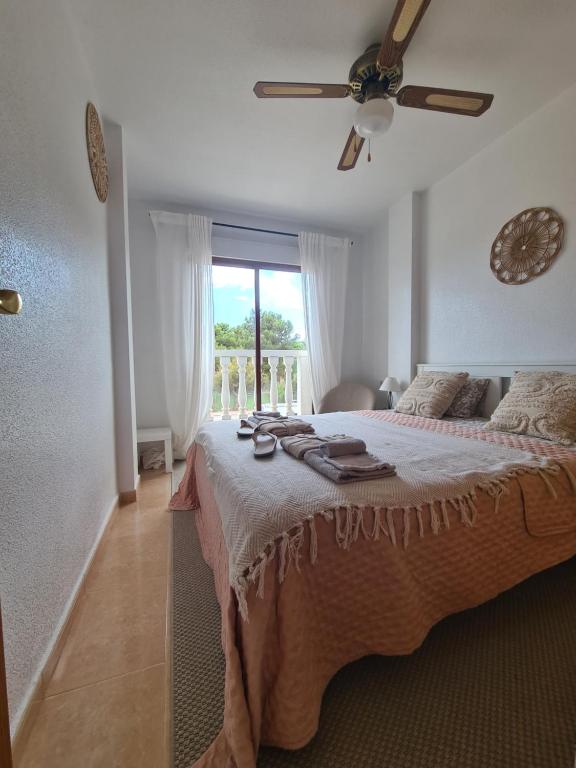 a bedroom with a bed with a ceiling fan and a window at Casa La Paz Bolnuevo in Bolnuevo