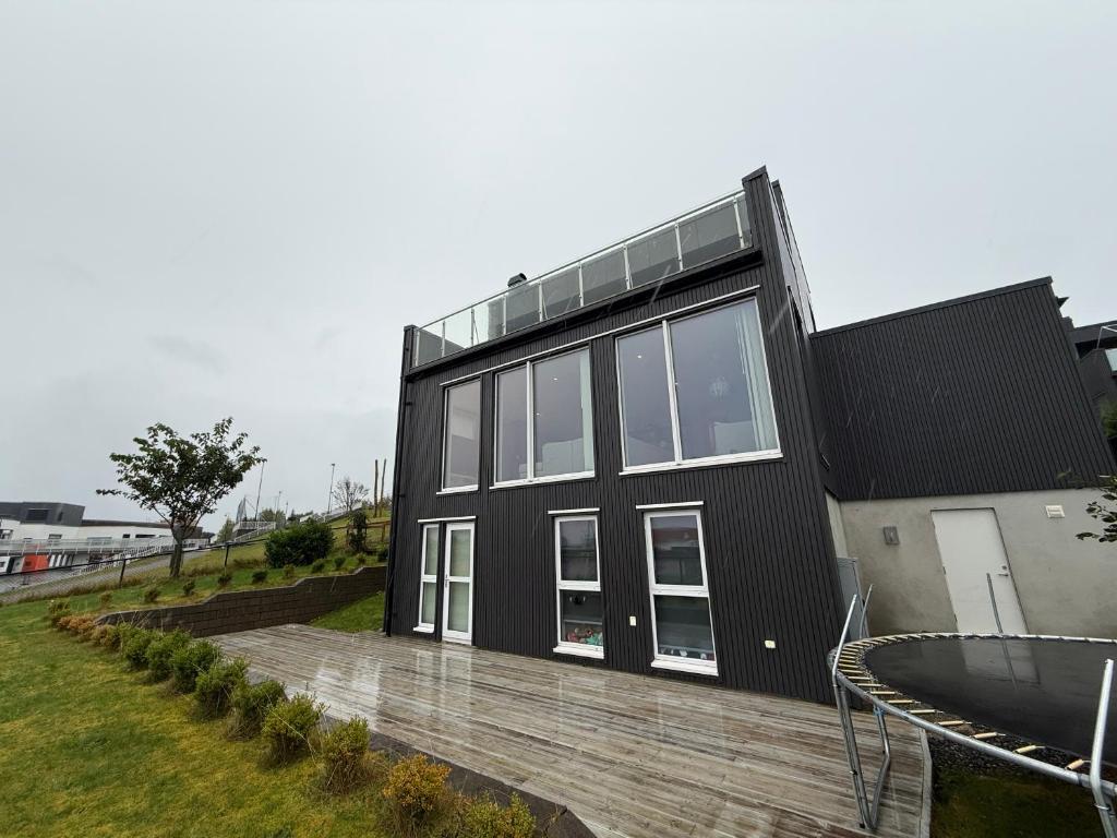 ein schwarzes Haus mit vielen Fenstern in der Unterkunft Luksuriøs enebolig, nær Ålesund in Ytterland