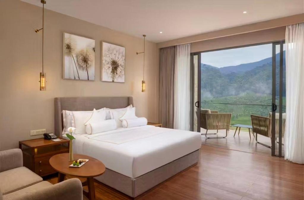 a bedroom with a large bed and a living room at Cottage 43 in Nuwara Eliya