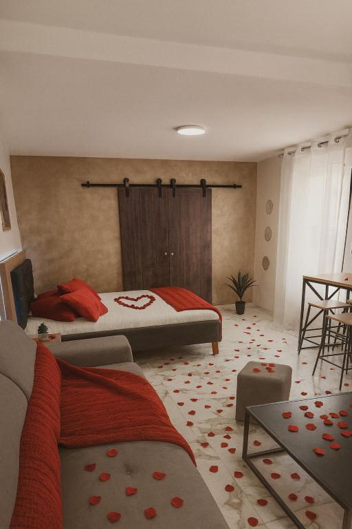 una camera da letto con due letti con lenzuola rosse di Evasion Romantique&Jacuzzi! a Pruniers