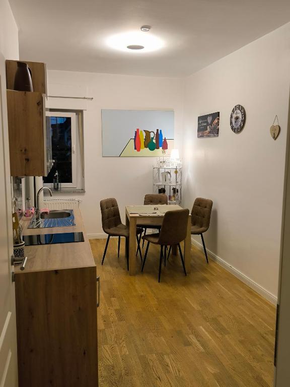 una cucina e una sala da pranzo con tavolo e sedie di AufmLohr - Appartement mit 3 Schlafzimmern- 4 Einzelbetten- für 4 Personen - in Leverkusen Hitdorf - Private Parkplätze vorhanden- a Leverkusen