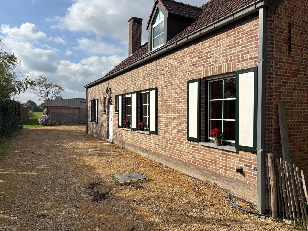 a brick building with windows and flowers in a yard at Bij Liezeke in Zemst