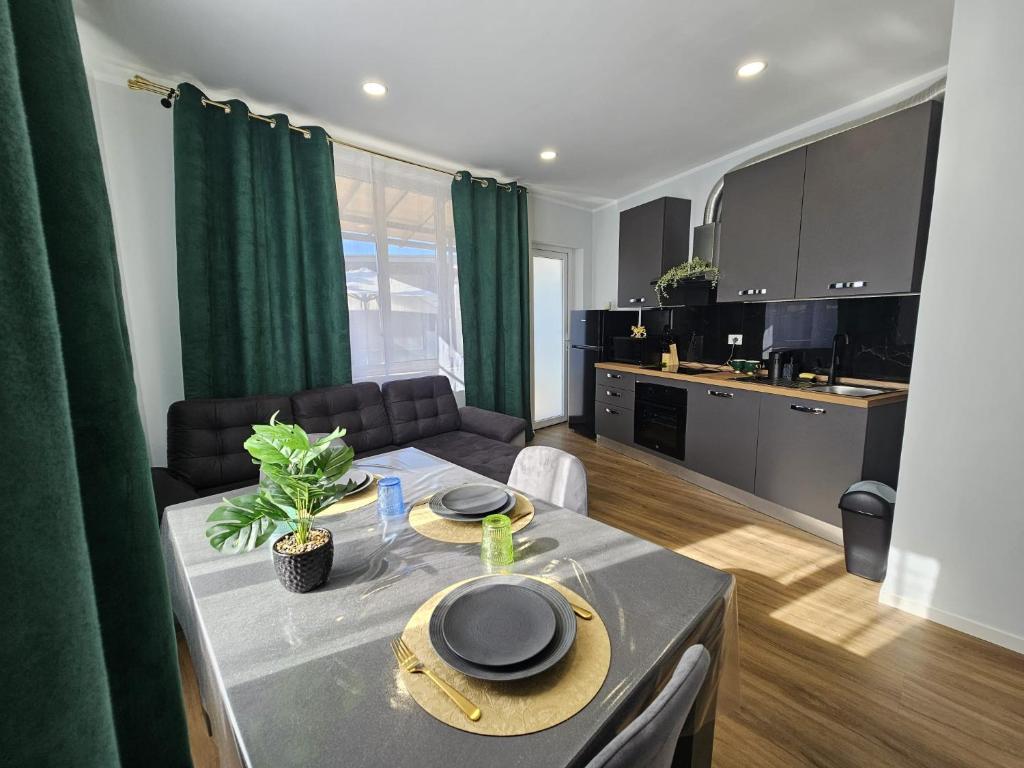 a kitchen and a living room with a table and a couch at Villa Kristin Residence in Monfalcone